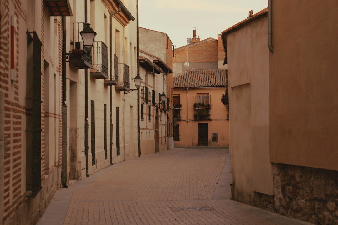 Empedrada calle nocturna con farolas y niebla en un casco histórico